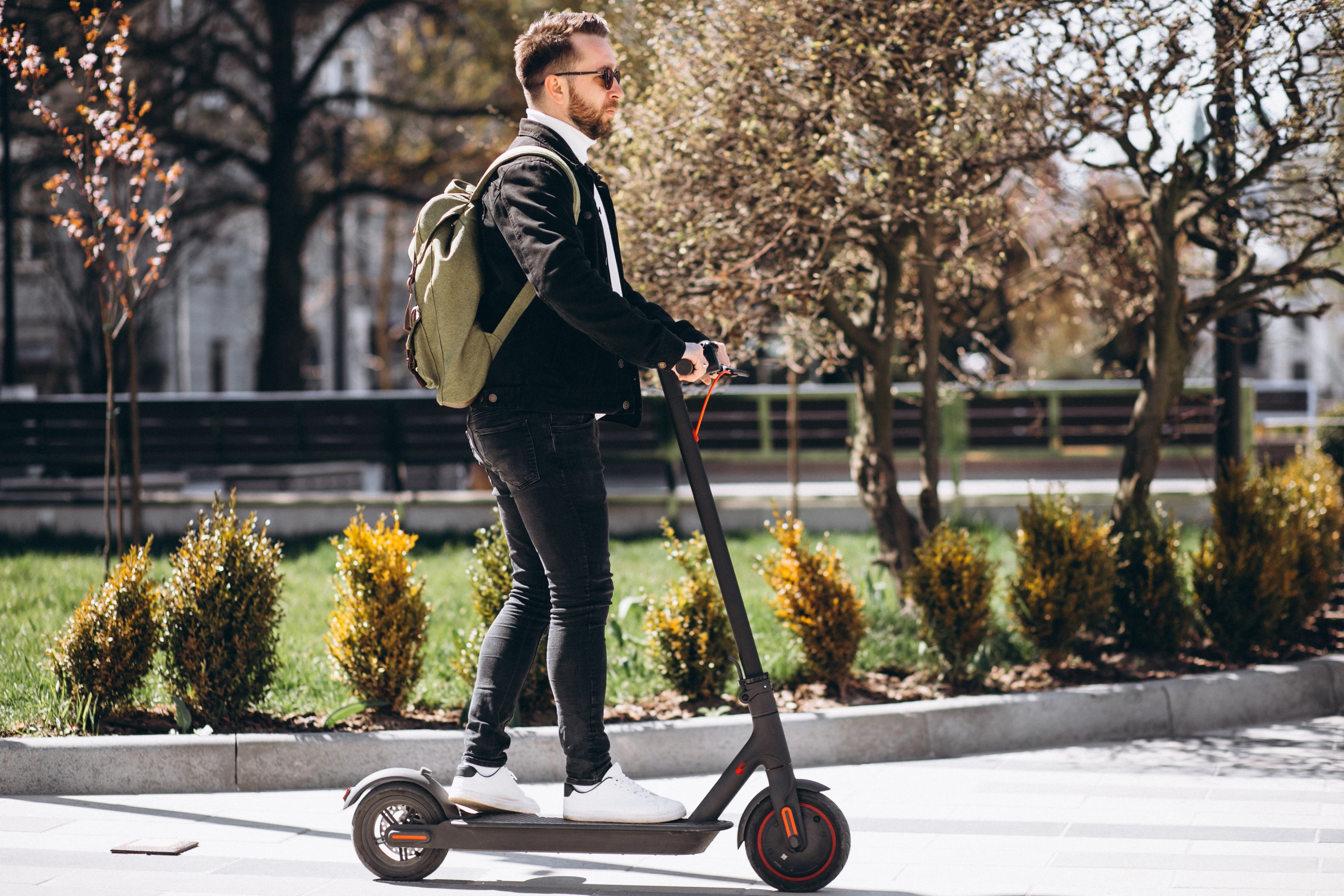 Young business man riding electric scooter